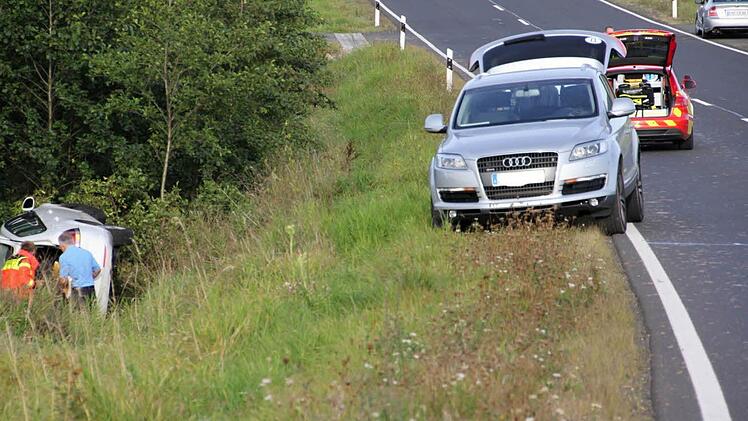 Abseits der Straße und in einem mehrere Meter tiefen Graben blieb der VW Golf auf der Seite liegen. Rasch waren Helfer zur Stele, um sich um die beiden Insassen des Fahrzeugs zu kümmern.  Foto: Helmut Will