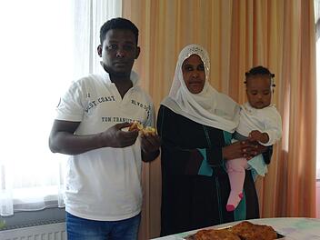 Ali Shire Hiirey (links) stand am längsten vor dem Herd. Nach acht Stunden Vorbereitung wurden seine Teigtaschen schließlich am Vormittag frisch frittiert. Ehefrau Rooda Yuusuf Omar und Töchterchen Khadria genießen ihre traditionellen Speisen.  Foto: Stephanie Elm