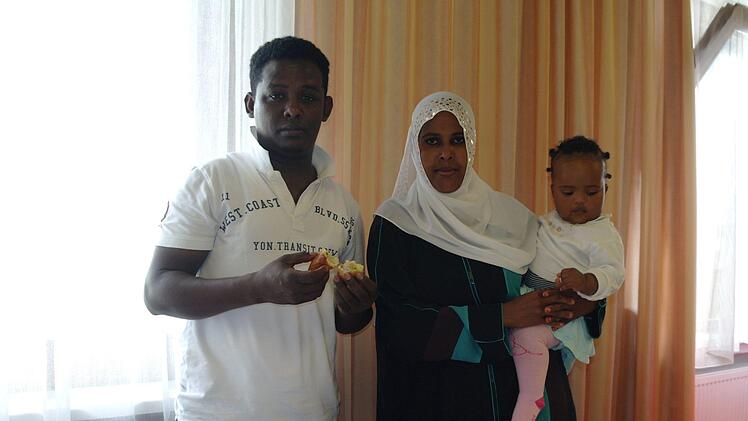 Ali Shire Hiirey (links) stand am längsten vor dem Herd. Nach acht Stunden Vorbereitung wurden seine Teigtaschen schließlich am Vormittag frisch frittiert. Ehefrau Rooda Yuusuf Omar und Töchterchen Khadria genießen ihre traditionellen Speisen.  Foto: Stephanie Elm
