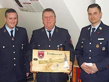 Peter Hassa bekam die Ernennungsurkunde zum Ehrenkommandanten von Kommandant Alexander Jantscher (rechts) und seinem Stellvertreter Dominik Maier überreicht. Fotos: Mathias Erlwein