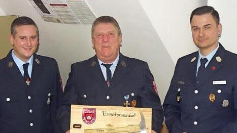 Peter Hassa bekam die Ernennungsurkunde zum Ehrenkommandanten von Kommandant Alexander Jantscher (rechts) und seinem Stellvertreter Dominik Maier überreicht. Fotos: Mathias Erlwein