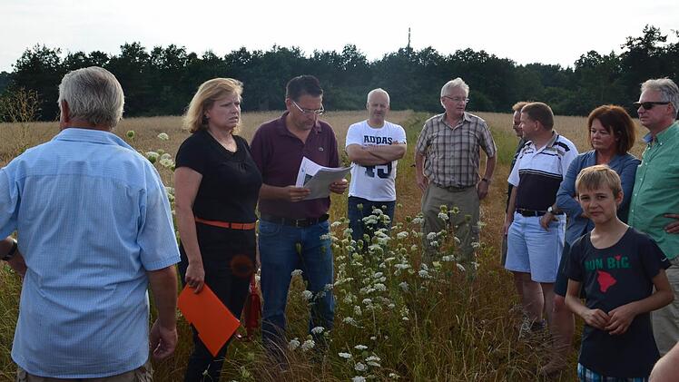 Wo gerade noch wilde Gräser wachsen, könnte schon bald eine PWC-Anlage die Idylle stören. Gabi Schmidt und Karsten Fischkal (2. und 3. v. l.) sind sich einig: Eine solche Anlage braucht es nicht. Foto: Larissa Händel