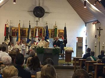 Der Gottesdienst in der Kirche - hinter den Fahnen  sieht man sehr schön die Ikonen von Peter Bauer.  Foto: Heidi Amon