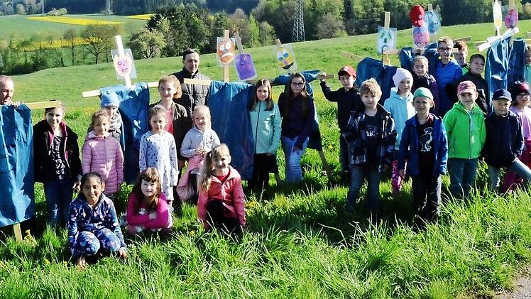 Die Tierschützer der Grundschule Stockheim überreichten an das Landwirtsehepaar Diana Hofmann (links) und Joachim Hofmann (hinten 3. v. l.) ihre selbst gebastelten Rehkitzscheuchen als Lebensretter für den Rehnachwuchs. Mit im Bild Lehrer Siegbert Jakob (2.  v. l.) und Rektorin Astrid Kestel (rechts) Foto: K.- H. Hofmann