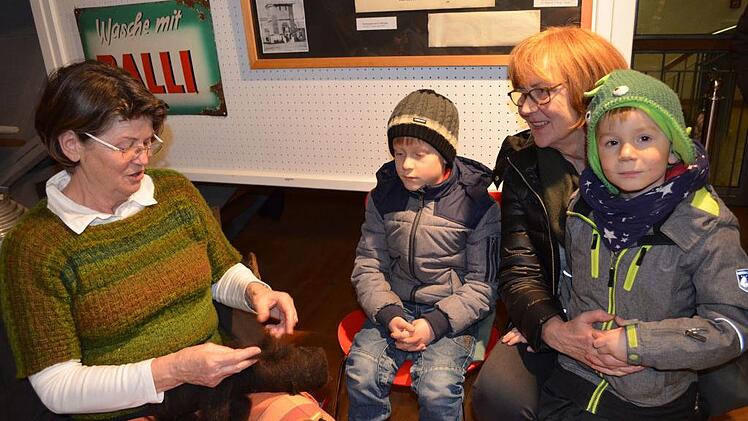 Mechthild Pauls und ihre Enkel Holger und Jakob schauen der Spinnerin Mechthild Schüler zu. Foto: Gabi Bertram