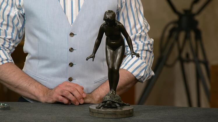 Colmar Schulte-Goltz erkl&auml;rte, die nackte Frau auf der Schildkr&ouml;te symbolisiere "Balance im Leben". Entworfen wurde das Original um 1900 von Richard Fabricius, die vorliegende Figur war aber ein Nachguss aus der zweiten H&auml;lfte des 20. Jahrhunderts. Wunschpreis: 1.500 Euro, Sch&auml;tzung: 500 Euro. Jos van Katwijk zahlte schlie&szlig;lich 350 Euro.