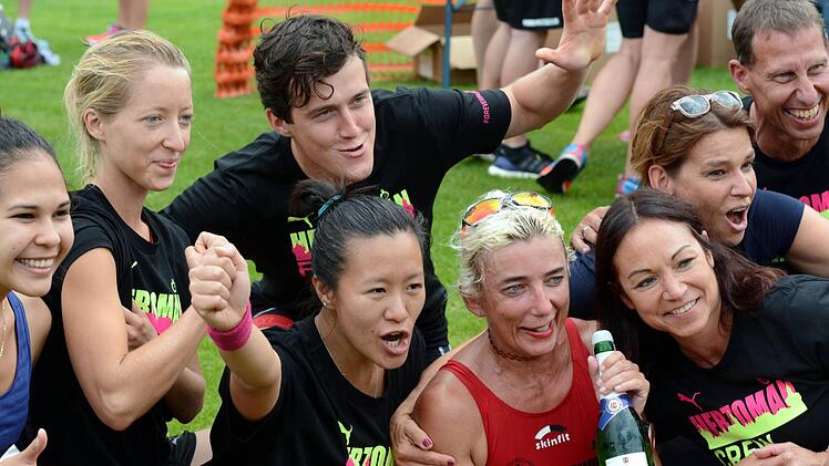 Petra Sticker (rot) von der TS Herzogenaurach wurde nach dem Zieleinlauf von ihren Arbeitskollegen und Bekannten mit einer Flasche Sekt zu ihrem neunten Platz beglückwünscht.  Foto: herzopress