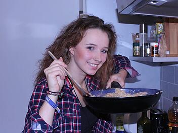 "Amy" Popadinets kocht gerne. In wenigen Minuten hat sie ein Pfannengericht nach chinesischer Art zubereitet - mit frischem Chinakohl, China-Gemüse aus dem Glas, Sojamedaillons, Kokosmilch, Sojasoße und Glasnudeln.  Foto: Ramona Popp