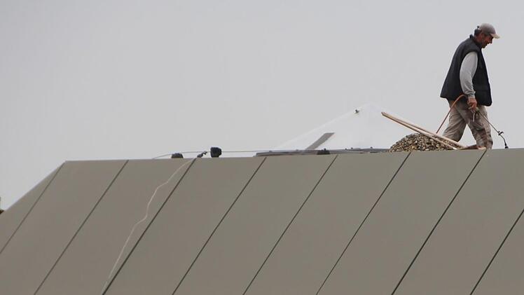 Die Aischtalhalle in Höchstadt  ist in die Jahre gekommen.  Dachdecker sind in diesen Tagen dabei, mit Gasbrennern schadhafte Schweißbahnen  zu erneuern. Foto: Christian Bauriedel
