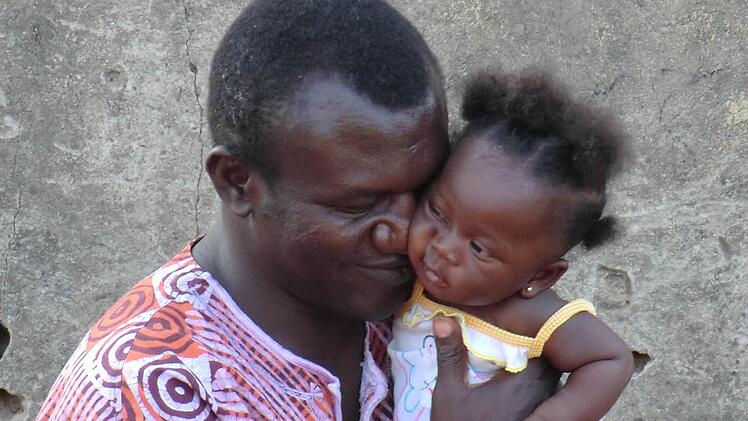 Pfarrer Martin in Ghana, mit Pia auf dem Arm