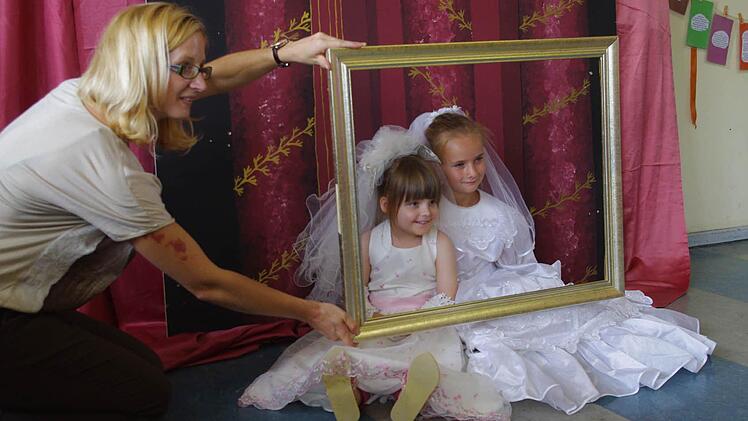 Mariella und Tabea (von links) lassen sich im Fotostudio als kleine Bräute fotografieren.