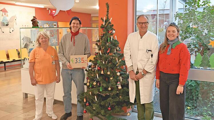 Die leitende Erzieherin Marion M&uuml;ller (l.) und Klinikdirektor Joachim W&ouml;lfle (3.&nbsp;v.&nbsp;l.) freuen sich sehr &uuml;ber die weihnachtliche Spende, die Xaver und Wanda Schiller vom &bdquo;Entla&rsquo;s-Br&auml;u&ldquo; Erlangen an sie &uuml;bergaben.