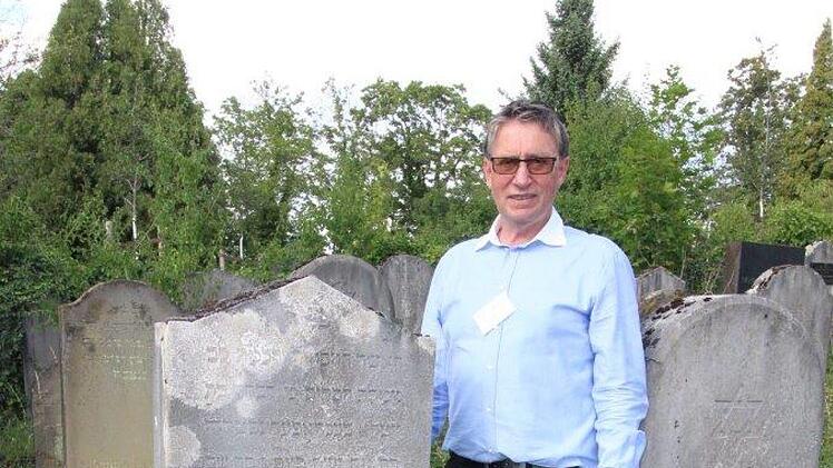 Friedhofsführer Roland Hubert neben dem Grabstein der im Alter von 95 Jahren am 18. Februar 1936 verstorbenen "großen Wohltäterin" Rebekka Bechhöfer aus Reckendorf im Würzburger Judenfriedhof, August 2019. Foto: Adelheid Waschka