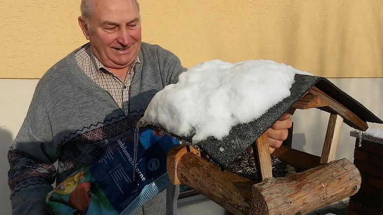 Konrad Behringer füllt Sonnenblumenkerne in sein Futterhäuschen. Foto: Sabine Christofzik