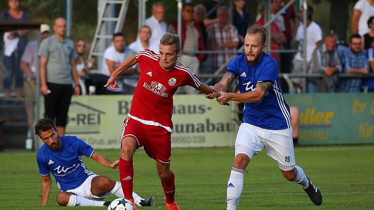 Dominic Lauerbach vom VfL Frohnlach (blau) kann sich nur noch mit einem Foul gegen Tom Thiel helfen.