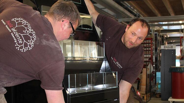 Holzakzente: Geselle Christian M&uuml;ller baut zusammen mit Azubi Nico Schneider einen Aufsteller f&uuml;r zum Beispiel Strumpfhosen auf. Foto: Ulrike M&uuml;ller