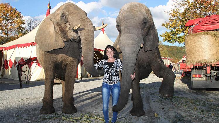 Diana Spindler vom "Circus Voyage" posiert mit zwei der Elefanten vor dem Zelt-Gehege. Foto: Thomas Heuchling