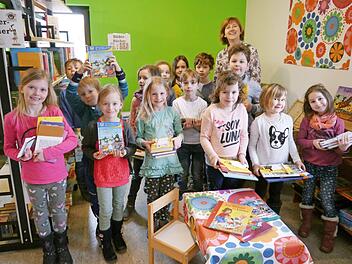 Die Mädchen und Jungen der 1. Klasse zeigen stolz, welche Bücher sie sich ausleihen.  Foto: Oswald Türbl