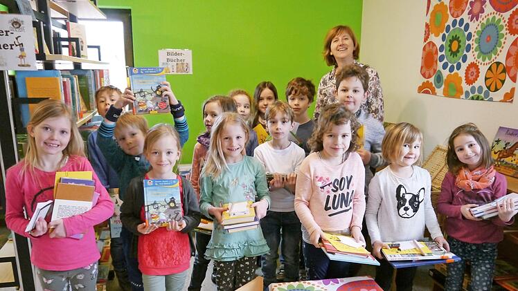 Die Mädchen und Jungen der 1. Klasse zeigen stolz, welche Bücher sie sich ausleihen.  Foto: Oswald Türbl