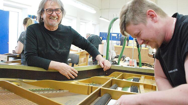 Rolf Müller und Enrico Glowatzki beim kurzen Plausch über den Flügel. Saiten polieren gehört zur Arbeit dazu.Christiane Lehmann