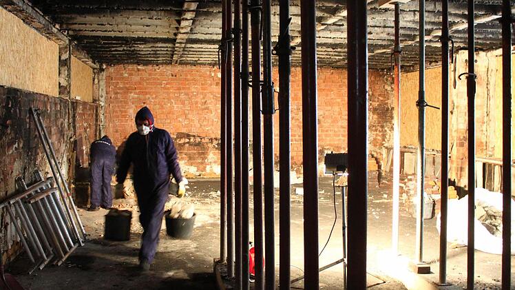 Die Brandsanierer der Fürther Firma Pfeifer sind dabei, den ausgebrannten Raum vom Schutt zu befreien. Bei dem Feuer im Oktober war ein Schadenin Höhe von insgesamt 280 000 Euro entstanden. Foto: Jürgen Gärtner