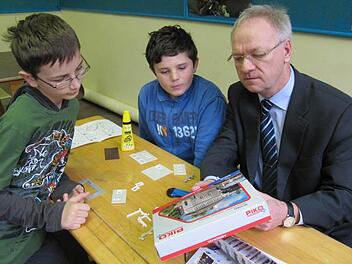 Eine kurze Besprechung vor dem Basteln (von links): Daniel Lunz, Dominik Lohneis und Otmar Kerner von der Raiffeisen-Volksbank überlegen sich, wie das Stellwerk am Eingang zur Bahnhofsanlage  entstehen soll.