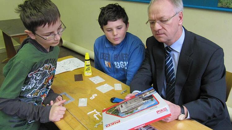 Eine kurze Besprechung vor dem Basteln (von links): Daniel Lunz, Dominik Lohneis und Otmar Kerner von der Raiffeisen-Volksbank überlegen sich, wie das Stellwerk am Eingang zur Bahnhofsanlage  entstehen soll.