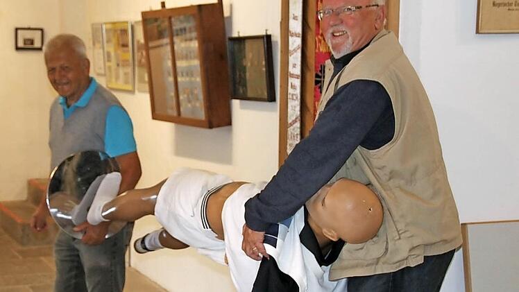 Karli Zeischka (hinten) und Diethard Hanshans (rechts) transportieren eines der letzten, noch fehlenden Ausstellungsstücke.