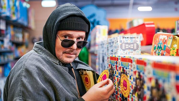Stefan (Thomas Mraz) klebt bei seinem ersten Einsatz als Neu-Aktivist Warnaufkleber auf Plastikspielzeug. Wenig später wird er für ebendieses Werbung machen.