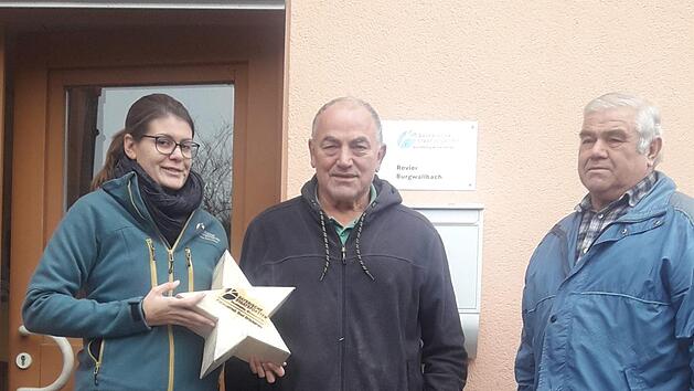 Miriam Langenbucher (Revierleiterin), Stefan Zehfu&szlig; (Vorsitzender des Vereins) sowie Bernhard Reupelt (ehemaliger Forstwirt) pr&auml;sentieren die Kiefernsterne-Spendenaktion. Foto: Reiner Balling