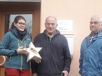 Miriam Langenbucher (Revierleiterin), Stefan Zehfuß (Vorsitzender des Vereins) sowie Bernhard Reupelt (ehemaliger Forstwirt) präsentieren die Kiefernsterne-Spendenaktion. Foto: Reiner Balling