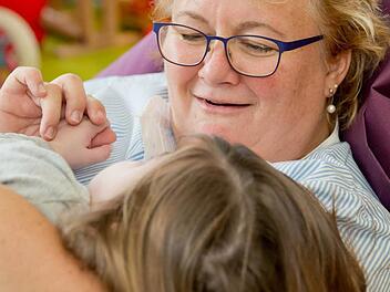 Eine Erlanger Fachkrankenschwester vom Kinderpalliativteam mit einem Mädchen, das an einer seltenen Krankheit leidet. Foto: Archiv/dpa-Bildfunkv