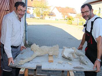 Nikolaus (links) und Konrad Gehringer mit dem schwer beschädigten Korpus ihres Feldkreuzes. Foto: Matthias Einwag