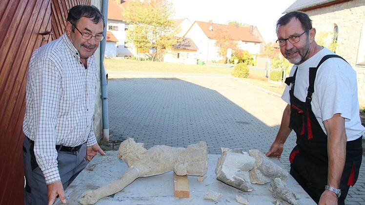 Nikolaus (links) und Konrad Gehringer mit dem schwer beschädigten Korpus ihres Feldkreuzes. Foto: Matthias Einwag
