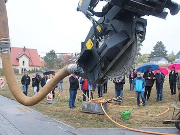 Das Fräswerk schneidet einen zehn Zentimeter breiten Graben in den Asphalt; das Erdreich wird dann vom Saugbagger entnommen. Anschließend werden die Glasfaserkabel in dem 40 Zentimeter tiefen Graben verlegt.Matthias Einwag