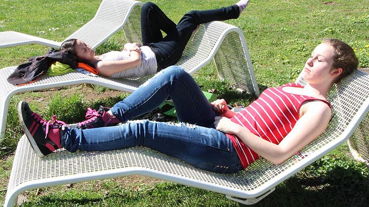 Die Schülerinnen Julia Stumpf und Alicia Schierhalt nutzen die Mittagspause, um im Stadtpark zu entspannen und Sonne zu tanken.