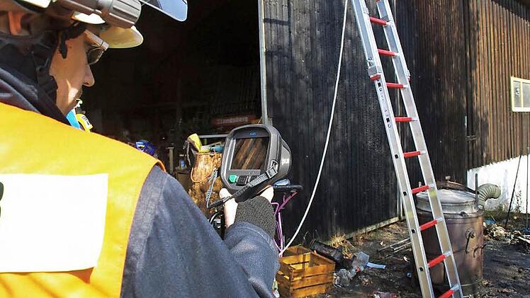 Ein Feuerwehrmann sucht mit einer Wärmebildkamera nach versteckten Glutnestern. Symbolfoto: Archiv/Marco Meißner