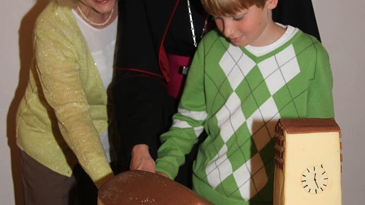 Der Erzbischof bekam zum Geburtstag einen Kuchen in Kirchenform überreicht. Unser Bild zeigt Schick mit Mesnerin Dana Moj und David Götz, die ebenfalls Geburtstag hatten. Foto: Sonja Adam