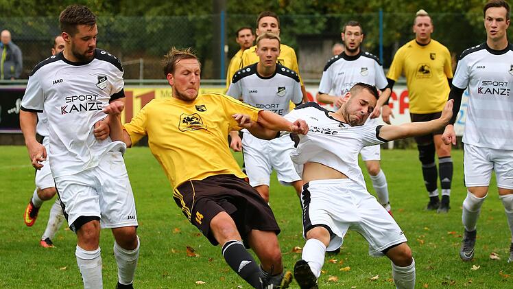 Kampf um den Ball zwischen Steinbergs Dominik Müller (weißes Trikot ) und Spielertrainer Colin Gloystein vom SV Steinwiesen.  Foto: Heinrich Weiß