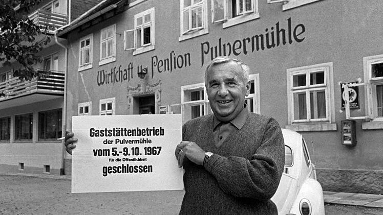 Der Vorsitzende der Gruppe 47, Hans Werner Richter, steht vor der Pulvermühle in Waischenfeld und zeigt ein Schild, das die Schließung der Gaststätte für das normale Publikum anzeigt. Archivfoto: Karl Schnörrer/dpa