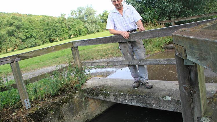 Rudolf Halbig steht am Mühlenkanal. Der ist zwar gefüllt, aber die Fließgeschwindigkeit ist durch die Trockenheit viel zu niedrig. Dadurch produziert das Wasserkraftwerk in der Mühle deutlich weniger Strom als üblich.