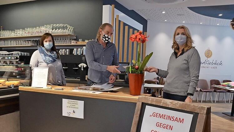 Gaby Richter und ihr Bruder Jürgen Rattmann starten heute ihre zweite Gutscheinaktion. Der Tisch steht im Café "Handgebäck", links die Geschäftsleiterin Elena Frühwald. Fotos: Bernhard Panzer