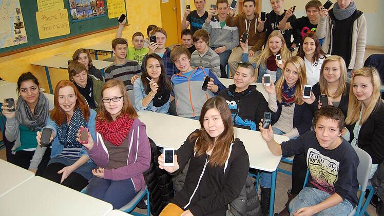 Noch können die Mädchen und Jungs der 8b lachend ihre Handys herzeigen - aber am Montag werden die Mobiltelefone für eine Woche weggeschlossen. Fotos: Oliver Schmidt
