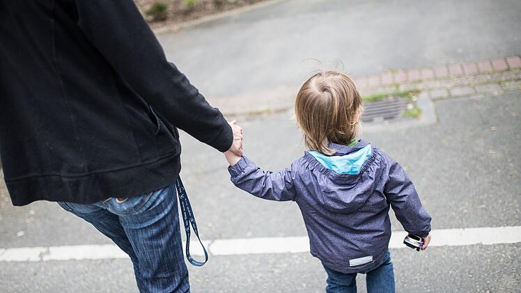 Eine Mutter h&auml;lt ihren Sohn an der Hand
