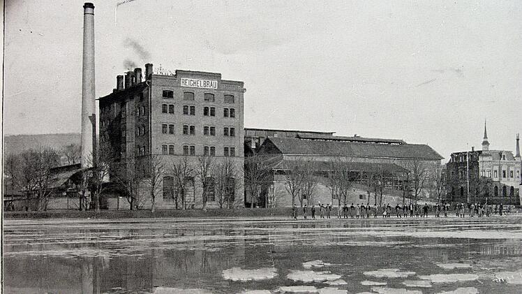 Das erste Eis ist "abgeerntet". Nur noch einzelne Bruckstücke schwimmen auf dem Reichelweiher. Im Hintergrund die Brauerei und die Erntemannschaft. Foto: Stadtarchiv