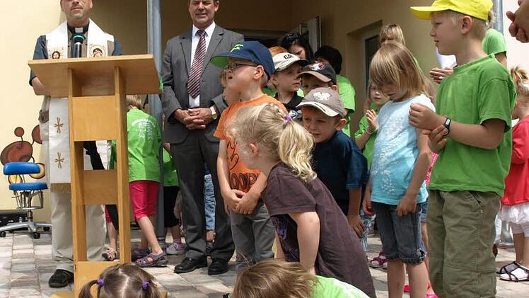 Pfarrer Richard Reis (links) bei der kirchlichen Segnung zusammen mit Bürgermeister Gerhard Wunder und vielen Kindern.