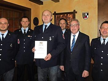 Thomas Weigel (mit Urkunde) erhielt für 25 Jahre Dienstzeit das staatliche Ehrenzeichen in Silber, Christoph Werner (rechts daneben) wurde als neuer Aktiver aufgenommen. Dazu gratulierten (von links) Vorsitzender Jörg Kolb, Kreisbrandmeister Thomas Hoffmann, Bürgermeister Harald Hübner und Kommandant Joachim Hübner. Foto: Horst Wunner