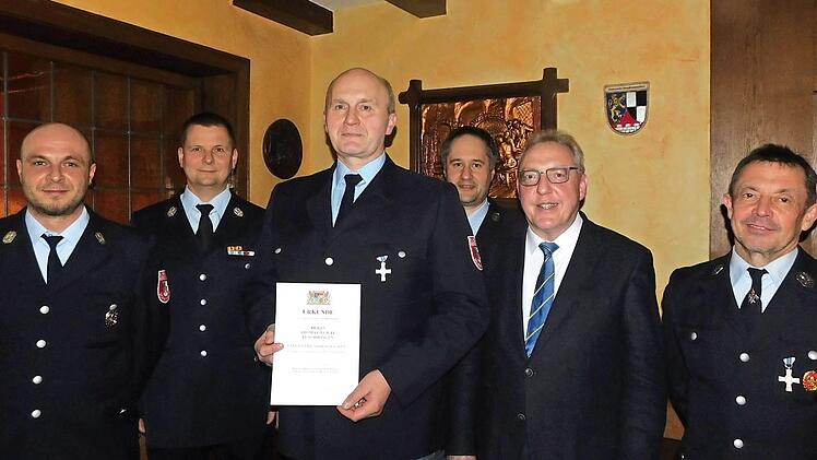 Thomas Weigel (mit Urkunde) erhielt für 25 Jahre Dienstzeit das staatliche Ehrenzeichen in Silber, Christoph Werner (rechts daneben) wurde als neuer Aktiver aufgenommen. Dazu gratulierten (von links) Vorsitzender Jörg Kolb, Kreisbrandmeister Thomas Hoffmann, Bürgermeister Harald Hübner und Kommandant Joachim Hübner. Foto: Horst Wunner
