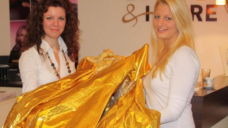 Vanessa Schmuck (rechts) präsentiert zusammen mit Jessica Grossmann von Friseur Essler und Haare das goldene Kleid, das die 17-Jährige als  Christkind tragen wird.   Foto: S.Martin