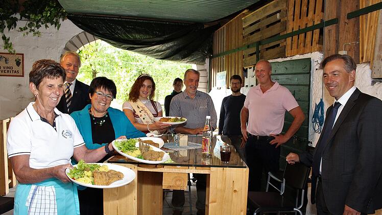 Knuspriges Karpfenfilet servierte Renate Rückel (von links) den Gästen in Mühlhausen. Im Bild Bürgermeister Klaus Meier (Neustadt/Aisch), Gästeführerin Christiane Kolbet, Karpfenkönigin Svenja Viertel, Doro Jordan (Aktionsgruppe Aischgrund),  Fischhändler Walter Jakob, Thomas Oppelt (Karpfenland-Aischgrund-Geschäftsführer), Bürgermeister Gerald Brehm und Landrat Alexander Tritthart.Evi Seeger